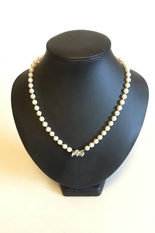 Perlehalskæde af runde hvide saltvandsperler med lås af 18kt. hvidguld med ni brillanter på tilsammen ca. 0.45 ct. Farve Top Wesselton (F-G), Klarhed: VS