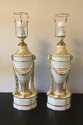 Royal Copenhagen A pair of baluster-shaped lamps on base decorated with garlands, Ram heads and gold. With Juliane Marie Stamp from 1905-12. Mounted with EL bulbs and wire.