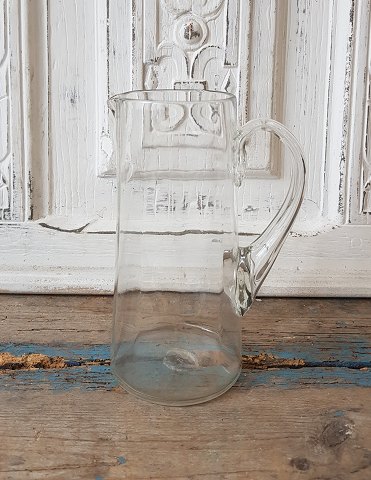 Old mouth-blown glass jug with twisted handle