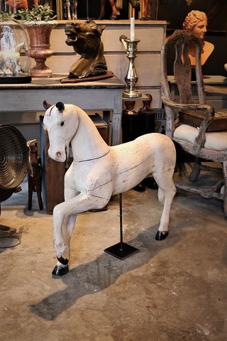 Svensk 1800 tals hest i udskåret træ med afskrabet råhvid farve og en super fin patina.H:76cm. L:88cm.