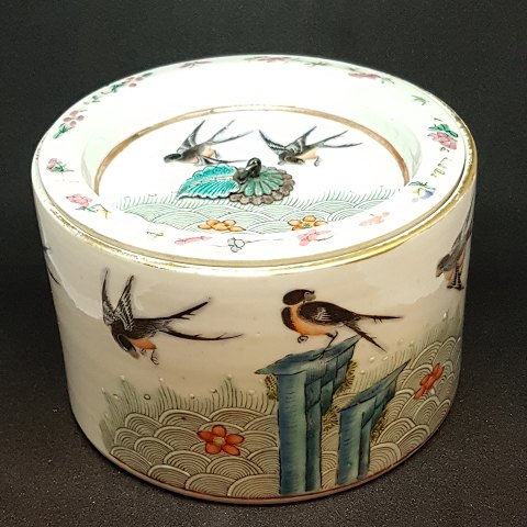Chinese lidded jar in porcelain. Decorated with birds. Lid with a leaf in silver and cloisonne, that is used as a handle.