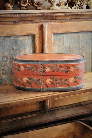 Svensk 1800 tals oval træ æske med original bemaling med blomstermotiv og med en fin patina.H:20cm. L&B: 47x28,5cm.