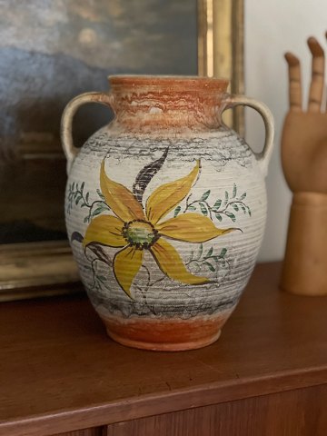 Smuk gl. lertøjsvase med stor gul blomst på meleret baggrund af beige, grå og orange. Cirka 1940