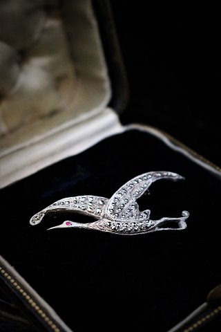 Gammel broche i sølv i form af fugl med masser af små skinnende magasiter. 5x2,5cm.