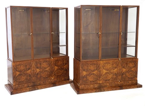Et par danske Art Deco vitriner af Bent Helweg-Møller, 1883-1956. Udført i nøddetræ hos Kongelig Hofleverandør C. B. Hansen, København, og med etiketter herfra. H: 171cm. B fod: 144cm. B vitrine: 126cm. D: 55cm