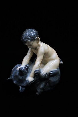 Royal Copenhagen porcelain figurine of Pan figurine sitting on bear. DJ#648. 2.sort. Height: 15,5cm.
