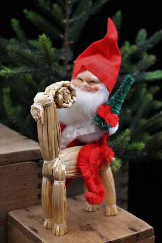 Gammel julenisse med vat skæg , nissehue , lille juletræ siddende på julebuk i halm. Højde:22 cm.
