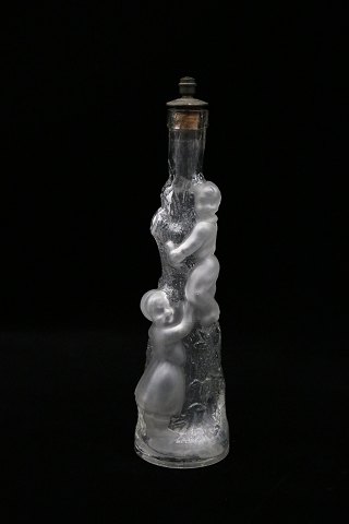Decorative, old mouth-blown glass carafe with a motif of children climbing up a tree trunk...