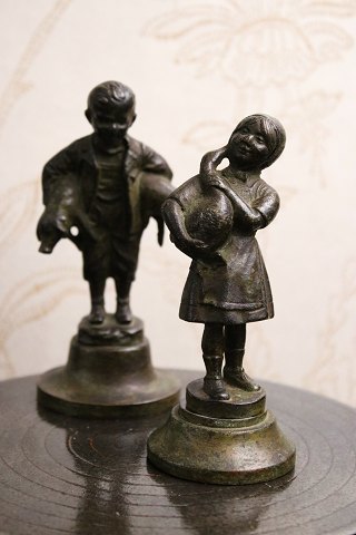 2 små dekorative bronze figurer af dreng med 2 grise under armen og pige der holder en gås...