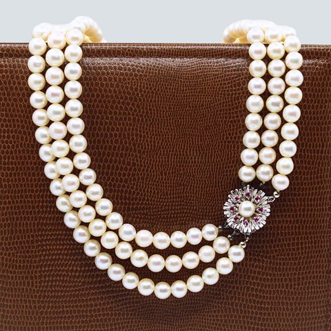 A pearl necklace with 14k white gold clasp set with rubies