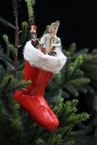 Gammel juletræspynt i form af en lille støvle i bemalet papmache med vatkant og fyld...