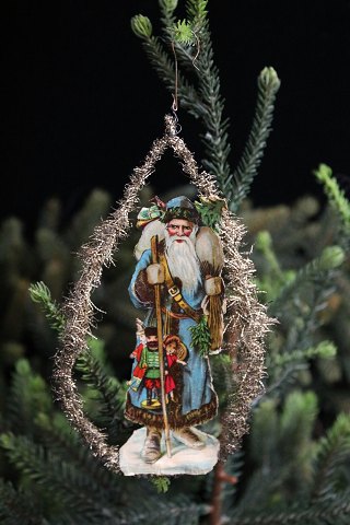 Antikt juletræspynt fra omkring år 1900 i form af julemands glansbillede og tinsel...