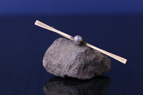 Propeller-shaped gold brooch in 14 carat gold, with pearl. Stamped 585
