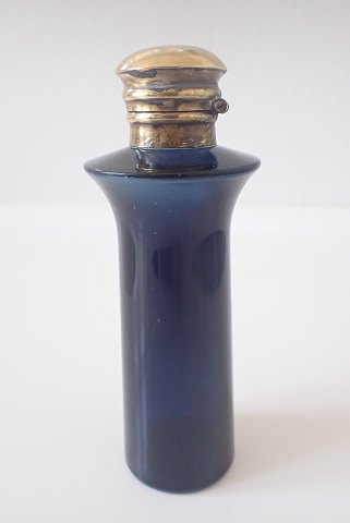 Parfumeflaske i blåt glas med messinglåg.