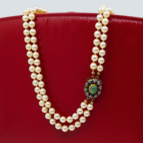 Pearl necklace with a 14k gold clasp, set with emerald and diamonds