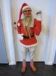 Julemand / UdstillingsnisseJulemanden løfter armen og hilserFørste halvdel af 1900-talletJulemanden er fremstillet i bemalet papmache og ståltrådsbeklædt træ med nissetøj og træsko Nissen har været brugt som udstillingsnisse