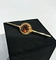Brooch in 14 ct. gold with amber colored stone.