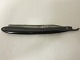 Barberkniv i etuiGammel barberknivL: 16,5cm, B: 3cm, H: 1,5cmVi har et stort udvalg af gammelt barbergrej, frisørudstyr o.l.