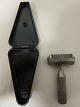 Hårtrimmer / Hårklipper / FrisørudstyrFrisørudstyr med original æske i sort bakelit, påtrykt "NOVO"Bemærk: Lille afstødning på kassens spidsL: 8cm, B: 4cm, H: 2cmVi har et stort udvalg af gammelt barbergrej, frisørudstyr o.l.
