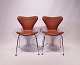 Et par syver stole, model 3107, i cognac farvet savanne læder, designet af Arne Jacobsen og fremstillet af Fritz Hansen. 5000m2 udstilling.