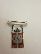 Royal batch made of Sterling silver 925S with red enamel motif of the DannebrogThis batch is made as a brooch with a beamYear 1870-1940 is on as well as Christian XThe Silver smithy of Georg Jensen produced it in 1940-47
