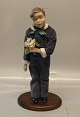 Bing & Grøndahl B&G 1986 Årsdukke "Hans"  38 cm m stativ og træstand På frierfødder dreng med blomster