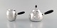 L'Art presents: Georg Jensen art nouveau teapot and milk jug in sterling silver with handle and knob in ebony. ...