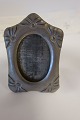 Photo frame, antiqueThis frame is made of metal, with a stand which can be folded upAbout the end of the 1800-years / the beginning of the 1900-yearsAbout 10,3cm x 7cmIn a good conditionWe have a large choice of photo frames