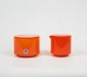 Orange glas sukkerskål og rød glas flødekande begge med hvidt opaline glas indvendigt fra Palet serien af Michael Bang for Holmegaard.
