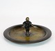 Rundt fad af bronze dekoreret med drengefigur.