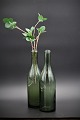 Decorative old glass bottle in green glass with a really nice patina in the glass itself. Really nice as a vase for a single flower or as water decanters.