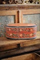Svensk 1800 tals oval træ æske med original bemaling med blomstermotiv og med en fin patina.H:20cm. L&B: 47x28,5cm.