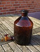 Large and well-maintained 5 liter apothecary bottle with pouring spoutin in dark brown glass. On the back there are liter measurements.