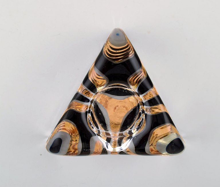 Ulrica Hydman Vallien for Kosta Boda, Sweden. Triangular candlestick in clear mouth blown art glass decorated with gold and black.