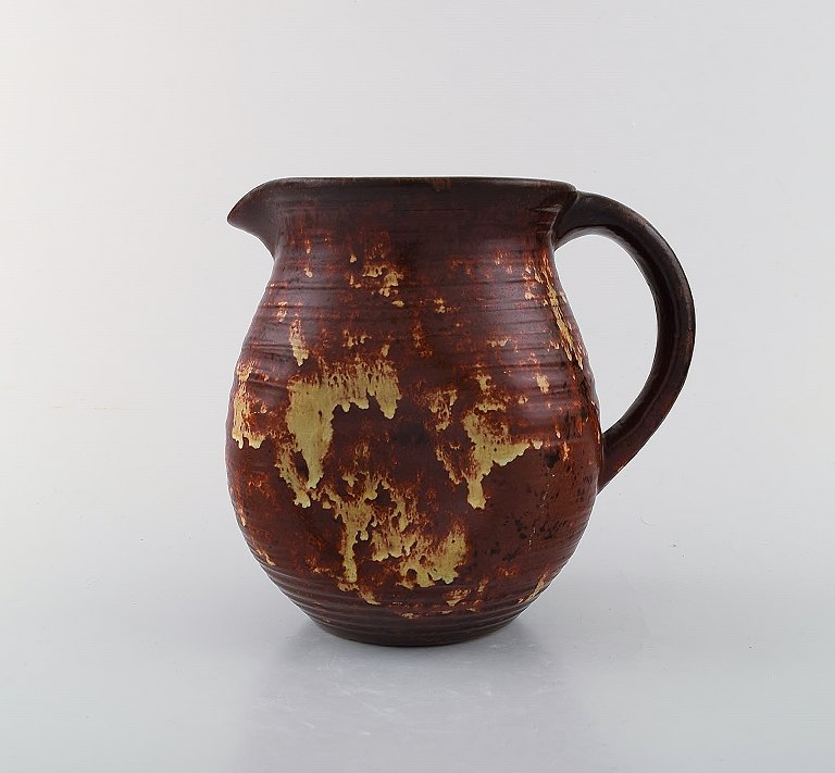 Michael Andersen, Denmark jug with handle. Beautiful glaze in red and yellow shades. 1950 / 60s.