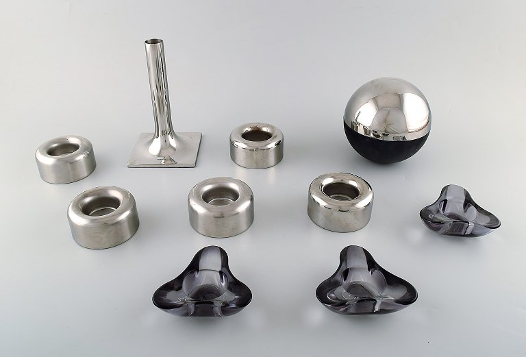 Stelton lysestage og juicepresser i rustfrit stål samt syv lysestager til fyrfadslys i lilla glas og rustfrit stål. Sent 1900-tallet.