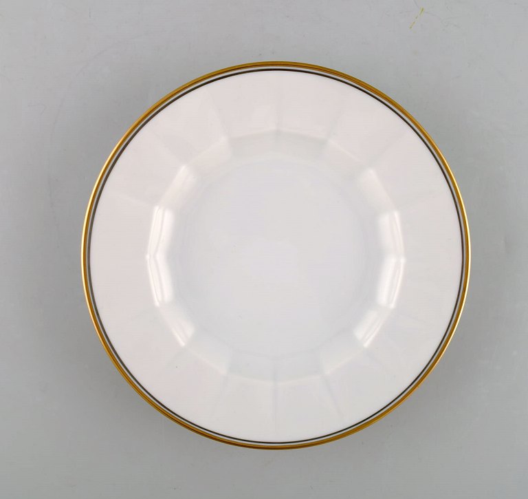 Royal Copenhagen. Three porcelain plates with gold border.