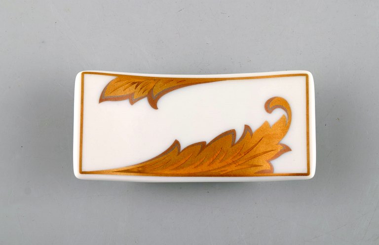 Gianni Versace for Rosenthal. "Arabesque Gold" porcelain knife rest with gold decoration. Late 20th century.
