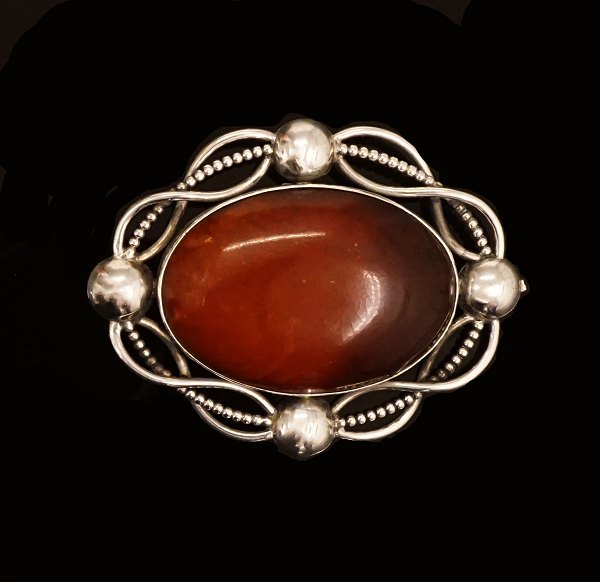 Otto Strange Friis: Gennembrudt broche af sølv med flettede sølvringe ovalt slebet ravstykke. Ca. år 1925. Mål: 6,7x5,1cm