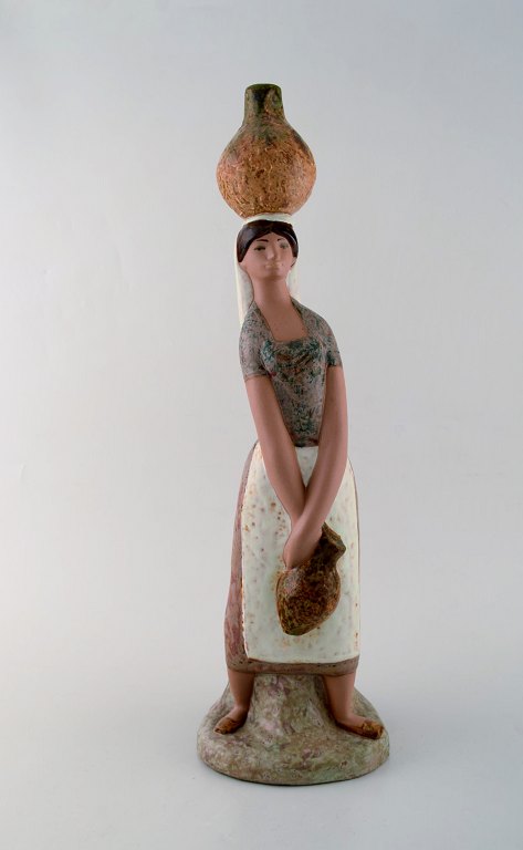 Lladro, Spain. Large figure in glazed ceramics. Woman carrying water. Late 20th century.