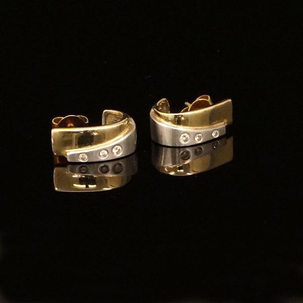 Et par ørestikker i 14kt guld prydet med hver tre diamanter på i alt ca. 0,04ct. Mål: 14x6mm