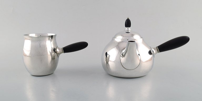 Georg Jensen art nouveau teapot and milk jug in sterling silver with handle and knob in ebony. Model Number 80A. Designed in 1915.