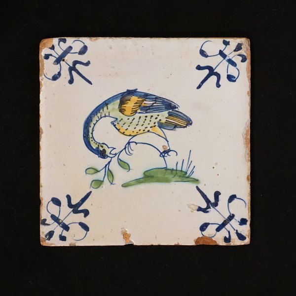 A 17th century polychrome decorated tile with a bird. Circa 1620-40. Size: 13x13cm