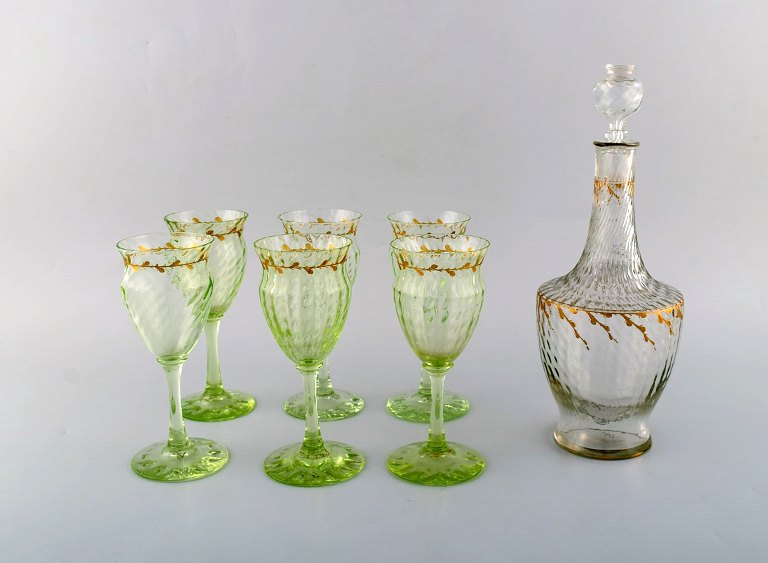 Emile Gallé (1846-1904). Six early and rare wine glasses and carafe in mouth-blown light green art glass with hand-painted gold decorations in the form of leaves. Museum quality, 1870s / 80s.