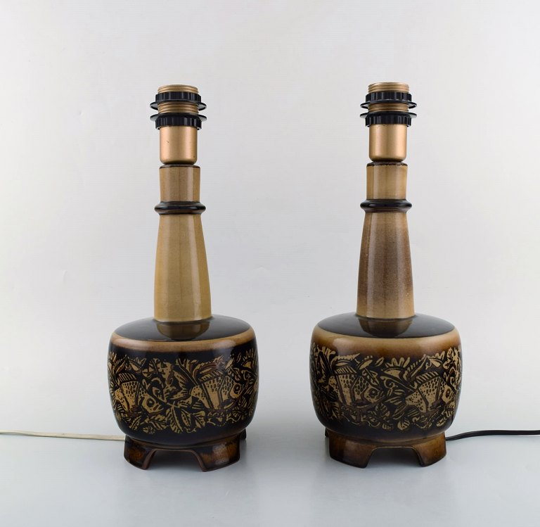 Nils Thorsson (1898-1975) for Royal Copenhagen. To bordlamper af stentøj opsat på fire fødder dekoreret med fiskemotiver.