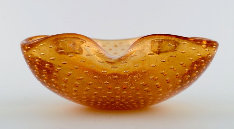 Murano bowl in amber colored mouth-blown art glass with inlaid air bubbles. Italian design, 1960