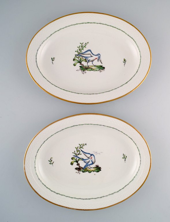 To store ovale Royal Copenhagen serveringsfade i håndmalet porcelæn med fuglemotiver og gulddekoration. Tidligt 1900-tallet. 