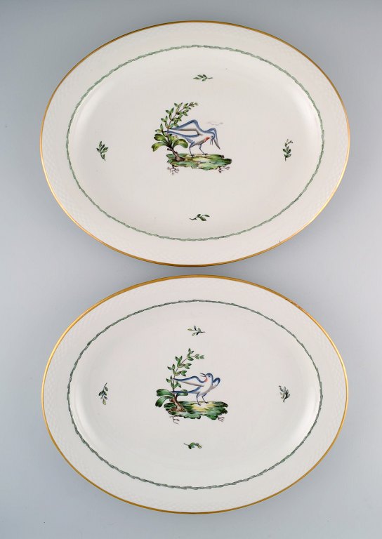 To store ovale Royal Copenhagen serveringsfade i håndmalet porcelæn med fuglemotiver og gulddekoration. Tidligt 1900-tallet. 