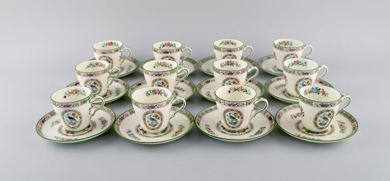 Wedgwood, England. Coffee service for 12 people in hand-painted porcelain with flower decoration and birds. About 1930.