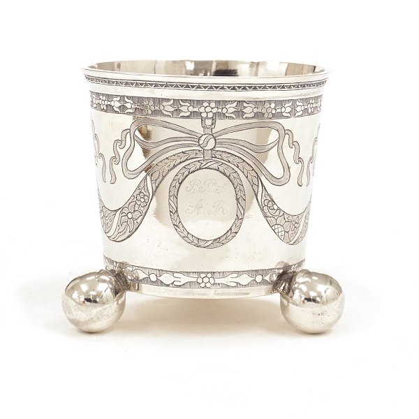 Louis XVI sølvbæger på tre kuglefødder. Fremstillet af H. W. Schorler, Næstved, og efterstemplet i København 1782. H: 8,4cm. V: 107,7gr